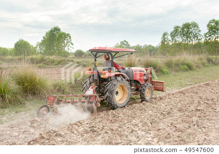 Tractor working plows a field on the farm for 49547600