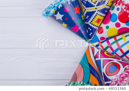 Set of colorful party hats on wooden table. Set of colorful party hats on wooden table. 49551360