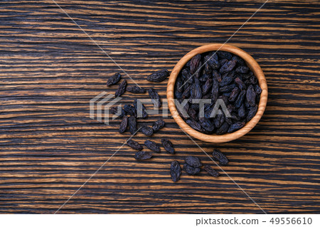 black raisins in bowl on table black raisins in bowl on table 49556610