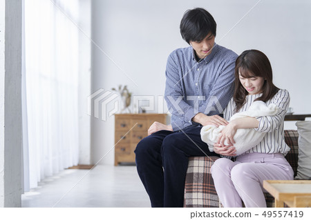 一對夫婦抱著一個嬰兒 49557419