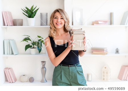 Female student holding books. Beautiful blonde girl keeps a stack of books and smiling. The concept Female student holding books. Beautiful blonde girl keeps a stack of books and smiling. The concept 49559089