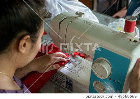 Woman seamstress working making clothes on a sewing machine. 49560669