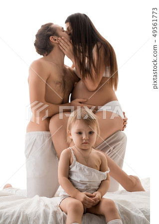 Baby sitting near kissing parents Baby sitting near kissing parents 49561773