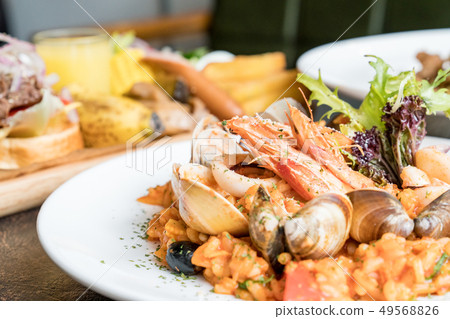 美味的平底鍋炒海鮮飯。頂面茄子，鮭魚，煎餅，海鮮。 49568826
