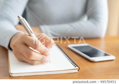 Asian women take notes with a pen in the office 49570451