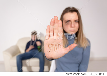People, domestic violence and abuse concept - Woman shows stop abusing sign over man's background People, domestic violence and abuse concept - Woman shows stop abusing sign over man's background 49571891