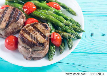 Grilled filet mignon with asparagus and tomatoes Grilled filet mignon with asparagus and tomatoes 49572031