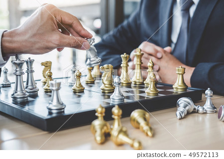 Two businessman playing chess game to plan 49572113