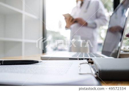 Blurred of doctor checking patient history form Blurred of doctor checking patient history form 49572334