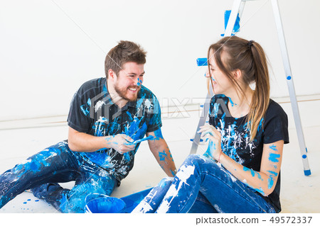 People, redecoration and relationship concept - Young funny couple doing renovation in new apartment People, redecoration and relationship concept - Young funny couple doing renovation in new apartment 49572337