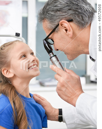 Oculist checking with special tool eyes of girl in clinic Oculist checking with special tool eyes of girl in clinic 49572608