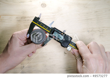 male hands with digital caliper male hands with digital caliper 49573277