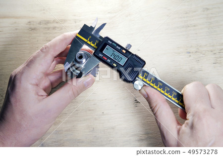 male hands with digital caliper male hands with digital caliper 49573278