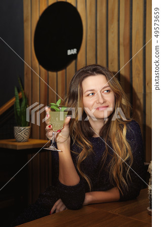 Pretty girl drinking cocktail in bar 49573659