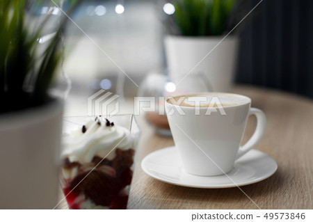 White cup of hot cappuccino on white saucer and 49573846