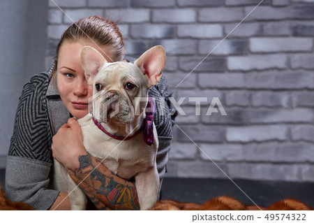 French bulldog on the hands of his master. It is felt that the girl loves her pet and hugs and kiss 49574322