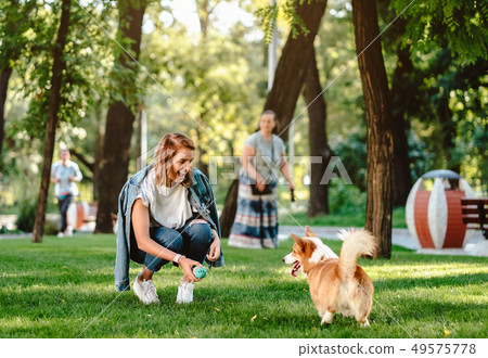 Portrait of woman with dog Welsh Corgi Pembroke in dog park Portrait of woman with dog Welsh Corgi Pembroke in dog park 49575778