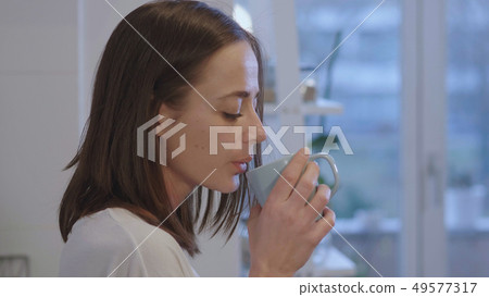 Tired girl in underwear drinks breakfast tea in the kitchen 49577317