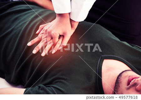 Rescuer hands doing CPR on heart attacked man. Rescuer hands doing CPR on heart attacked man. 49577618