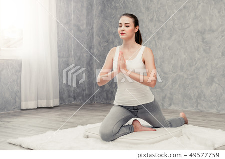 Young woman yoga on carpet at home living room. 49577759