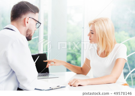Male Doctor and Female Patient in Hospital Office 49578146