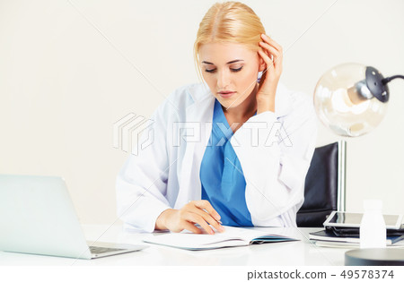 Doctor in hospital working on medical report. Doctor in hospital working on medical report. 49578374