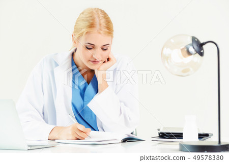 Doctor in hospital working on medical report. Doctor in hospital working on medical report. 49578380