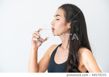 Woman in sportswear drinking water in fitness gym. Woman in sportswear drinking water in fitness gym. 49579335