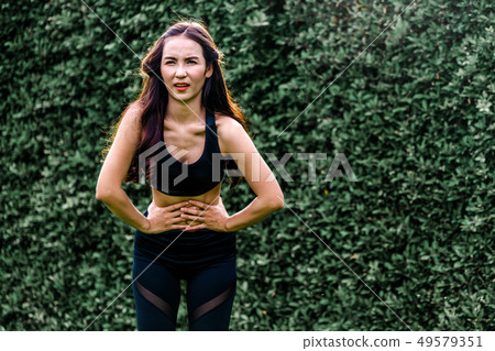 Young sport woman having pain at her stomach. Young sport woman having pain at her stomach. 49579351