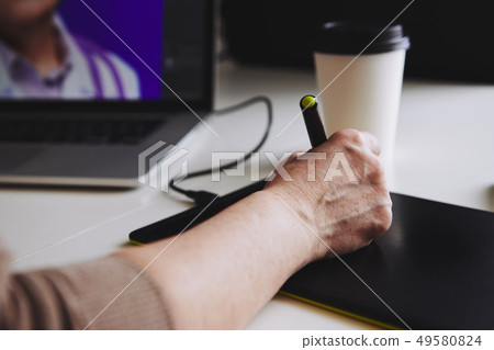Woman designer working at a laptop with a graphics tablet. Woman designer working at a laptop with a graphics tablet. 49580824