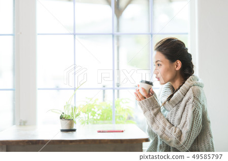 A woman relaxing at the window A woman relaxing at the window 49585797