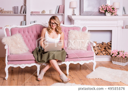 Woman in glasses working on computer. Casual blogger woman with laptop, working at home, female Woman in glasses working on computer. Casual blogger woman with laptop, working at home, female 49585876