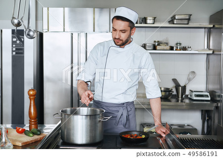 Expect the best. Chef cooking tasty dish in kitchen 49586191