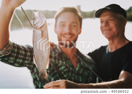 Old Father with Bearded Son Fishing on River. Old Father with Bearded Son Fishing on River. 49586932