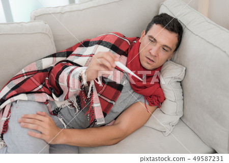 Man with Cold Sitting on Sofa in Checkered Blanket Man with Cold Sitting on Sofa in Checkered Blanket 49587231