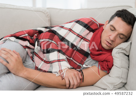 Man with Cold Resting on Sofa in Checkered Blanket Man with Cold Resting on Sofa in Checkered Blanket 49587232