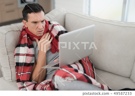 Man with Cold Sitting on Sofa in Checkered Blanket 49587233