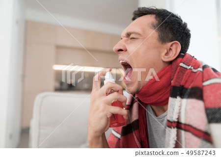Man with Cold Sitting on Sofa in Checkered Blanket Man with Cold Sitting on Sofa in Checkered Blanket 49587243