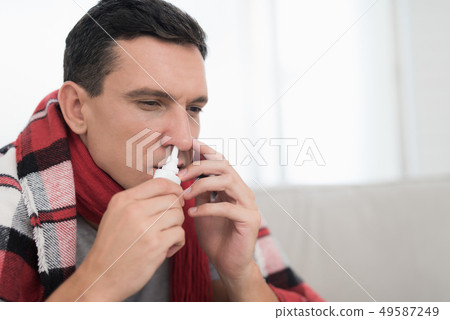 Man with Cold Sitting on Sofa in Checkered Blanket Man with Cold Sitting on Sofa in Checkered Blanket 49587249