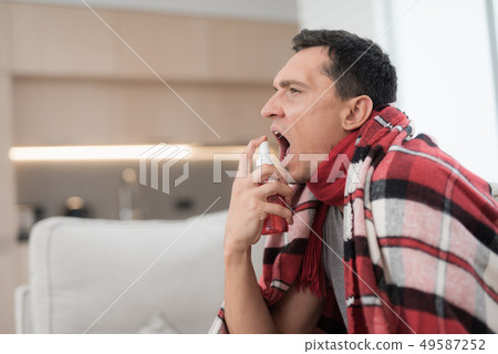 Man with Cold Sitting on Sofa in Checkered Blanket Man with Cold Sitting on Sofa in Checkered Blanket 49587252