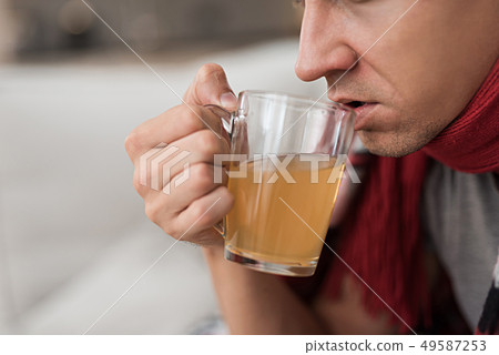 Man with Cold Sitting on Sofa in Checkered Blanket Man with Cold Sitting on Sofa in Checkered Blanket 49587253