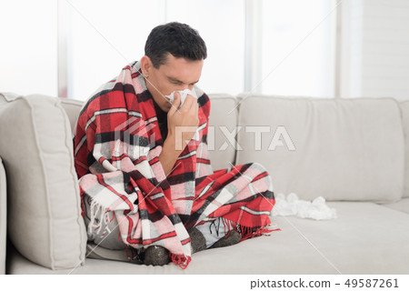 Man with Cold Sitting on Sofa in Checkered Blanket Man with Cold Sitting on Sofa in Checkered Blanket 49587261