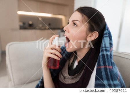 Upset Woman with Cold on Sofa in Scarf at Home. Upset Woman with Cold on Sofa in Scarf at Home. 49587611