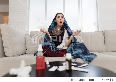 Upset Woman with Cold on Sofa in Scarf at Home. Upset Woman with Cold on Sofa in Scarf at Home. 49587613