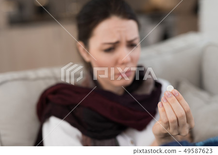 Upset Woman with Cold on Sofa in Scarf at Home. Upset Woman with Cold on Sofa in Scarf at Home. 49587623