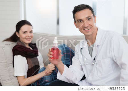 Doctor Visiting Sick Young Woman in Scarf at Home. Doctor Visiting Sick Young Woman in Scarf at Home. 49587625