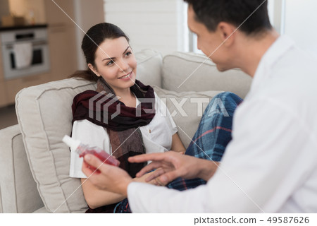 Doctor Visiting Sick Young Woman in Scarf at Home. Doctor Visiting Sick Young Woman in Scarf at Home. 49587626