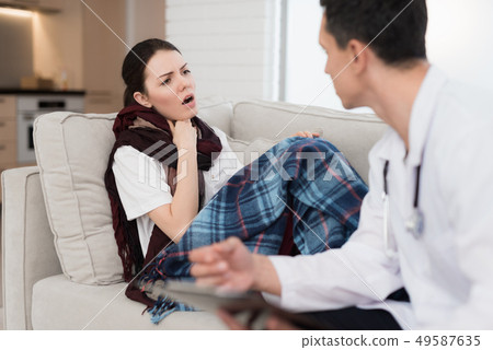 Doctor Visiting Sick Young Woman in Scarf at Home. 49587635