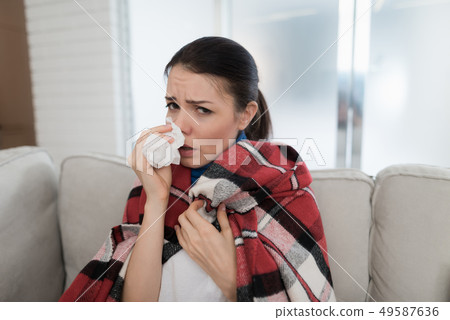 Woman with Cold on Sofa in Checkered Blanket. Woman with Cold on Sofa in Checkered Blanket. 49587636