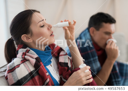 Sick Couple Sitting on Sofa in Checkered Blankets. Sick Couple Sitting on Sofa in Checkered Blankets. 49587653